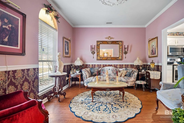 living room with crown molding, a healthy amount of sunlight, and hardwood / wood-style floors