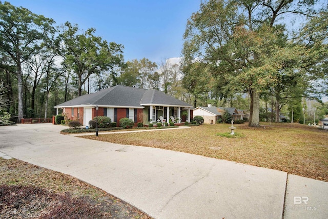 single story home featuring covered porch and a front lawn