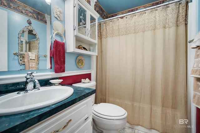 bathroom with toilet, tile patterned flooring, and vanity