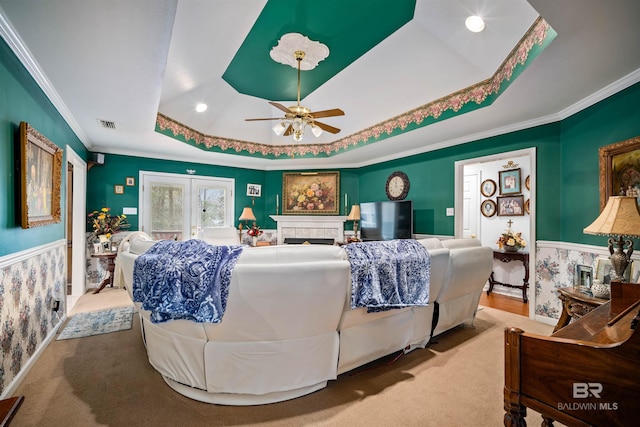 carpeted bedroom featuring ceiling fan, ornamental molding, and a raised ceiling