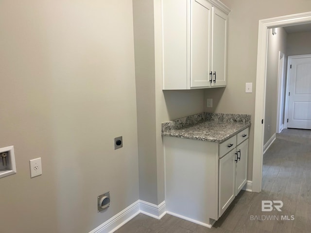 laundry area featuring cabinets, dark hardwood / wood-style flooring, and electric dryer hookup