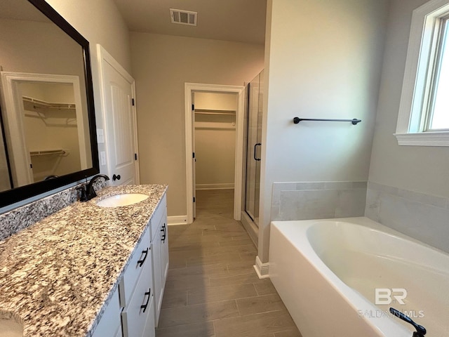 bathroom featuring separate shower and tub, vanity, and wood-type flooring