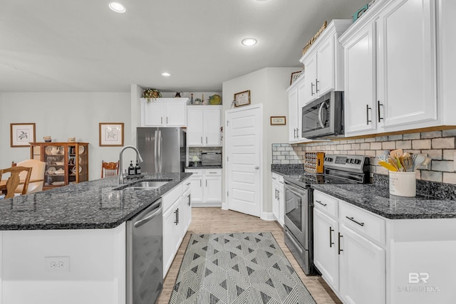 1556 Kairos Loop, Foley, AL 36535 - kitchen featuring appliances with stainless steel finishes, white cabinetry, an island with sink, tasteful backsplash, and recessed lighting