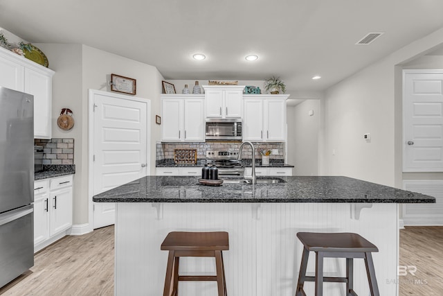 1556 Kairos Loop, Foley, AL 36535 - kitchen with stainless steel appliances, light wood-style floors, tasteful backsplash, white cabinets, and recessed lighting