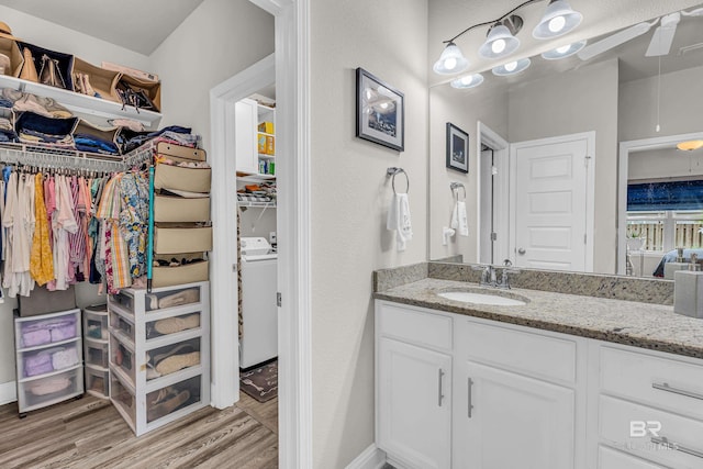 1556 Kairos Loop, Foley, AL 36535 - bathroom featuring vanity, washer and dryer, wood finished floors, and a walk in closet