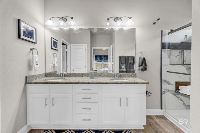 1556 Kairos Loop, Foley, AL 36535 - bathroom featuring a marble finish shower, double vanity, and wood finished floors