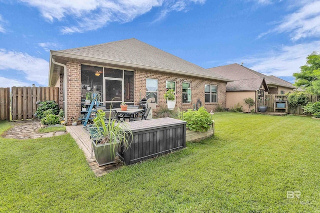 1556 Kairos Loop, Foley, AL 36535 - rear view of house featuring a fenced backyard, brick siding, roof with shingles, and a sunroom
