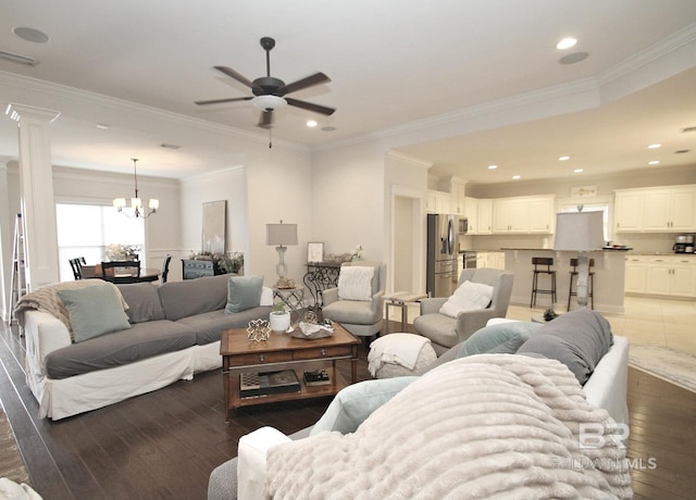 living area featuring recessed lighting, ceiling fan with notable chandelier, visible vents, ornamental molding, and dark wood finished floors