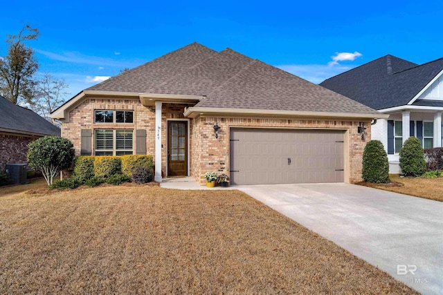 view of front of house with a garage, cooling unit, and a front yard