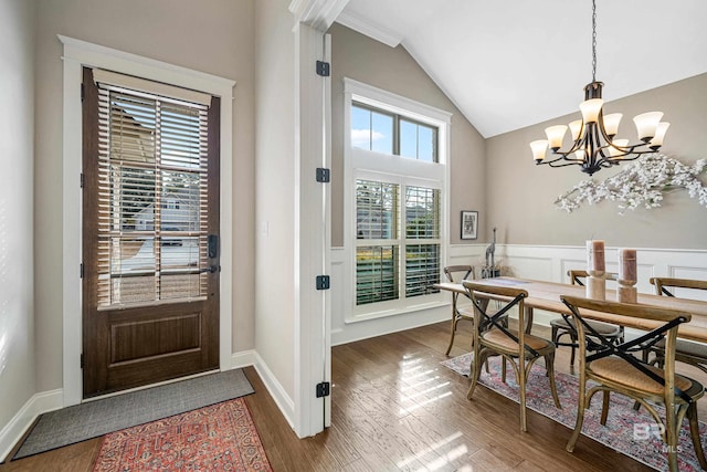 dining room featuring lofted ceiling, dark hardwood / wood-style floors, and an inviting chandelier