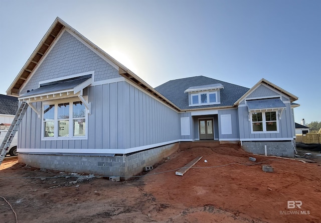 view of front facade with crawl space, board and batten siding, and roof with shingles