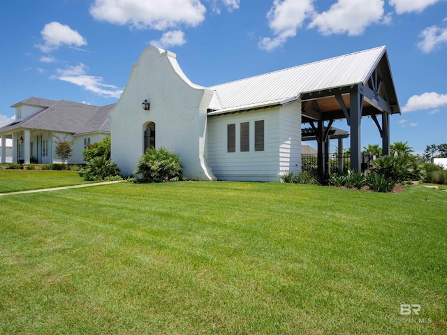 view of front of house featuring metal roof and a front lawn