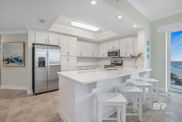 23008 W Perdido Beach Blvd Unit 1905, Orange Beach, AL 36561 - kitchen featuring stainless steel appliances, crown molding, a breakfast bar area, a peninsula, and baseboards