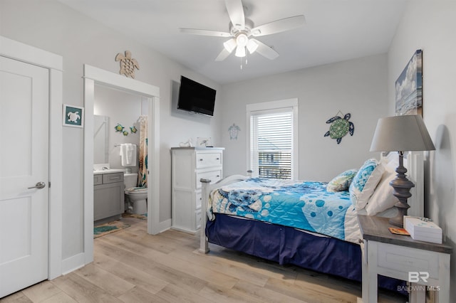 bedroom with light wood-style flooring, ceiling fan, baseboards, and connected bathroom