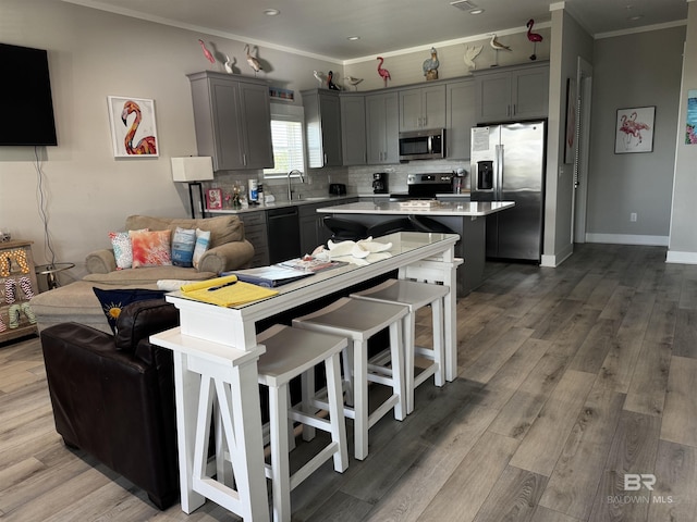 kitchen with a sink, light countertops, gray cabinetry, and stainless steel appliances