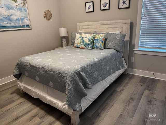 bedroom with baseboards and wood finished floors