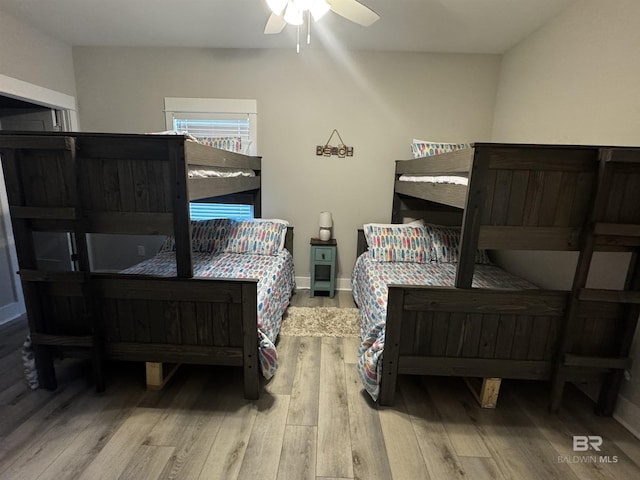 bedroom featuring ceiling fan, baseboards, and wood finished floors