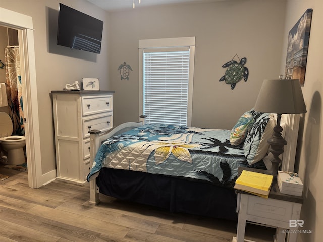 bedroom with wood finished floors and baseboards