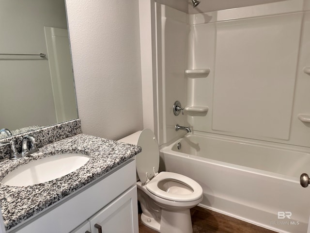 full bathroom with hardwood / wood-style floors, vanity, toilet, and  shower combination