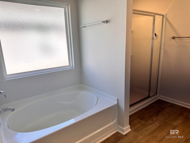 bathroom featuring plus walk in shower and wood-type flooring