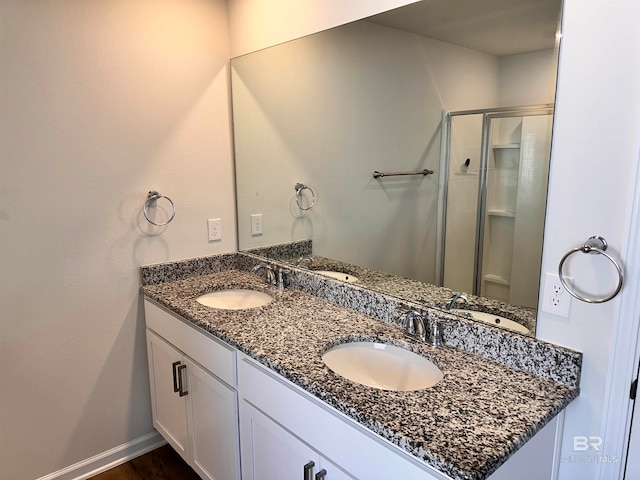 bathroom featuring hardwood / wood-style floors, vanity, and a shower with shower door