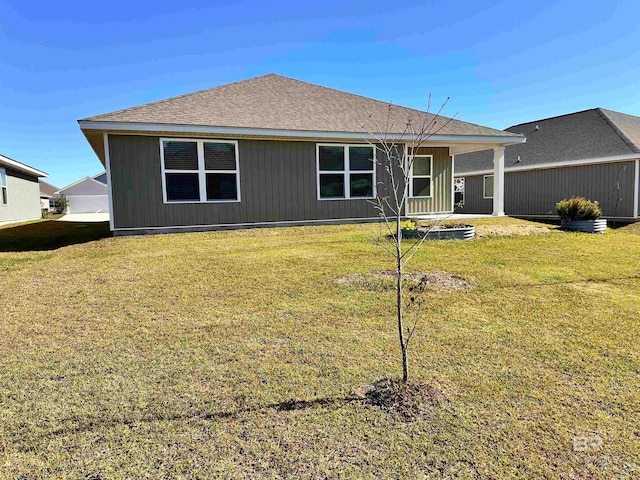 rear view of house featuring a lawn