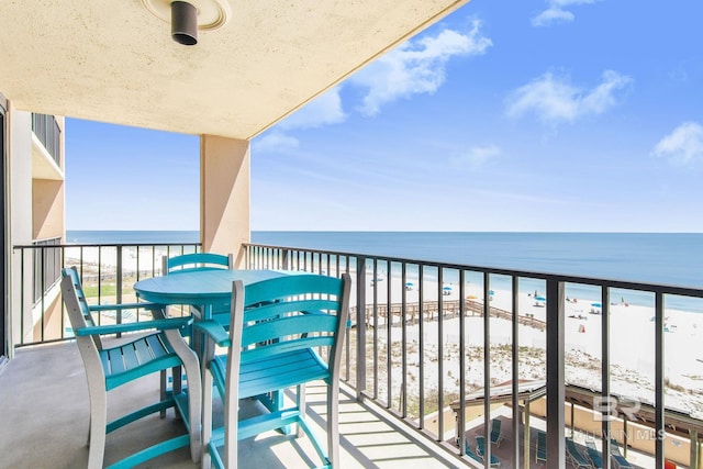 balcony with a water view and a beach view