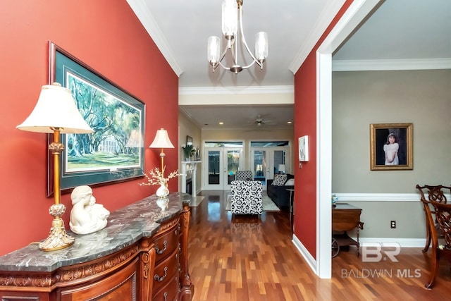 hallway featuring ornamental molding, an inviting chandelier, dark hardwood / wood-style flooring, and french doors