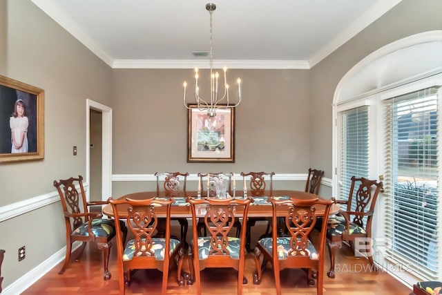 dining area with ornamental molding, hardwood / wood-style floors, and a notable chandelier