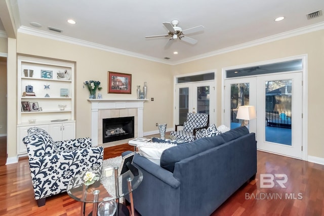 living room with wood-type flooring, crown molding, and french doors