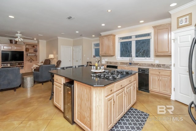 kitchen featuring sink, stainless steel gas cooktop, a kitchen island, beverage cooler, and light brown cabinets