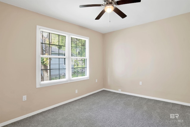 unfurnished room featuring dark colored carpet, baseboards, and ceiling fan