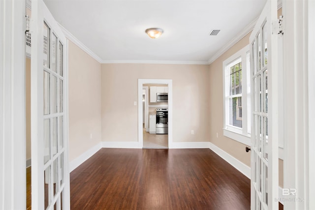 spare room with dark wood-type flooring, baseboards, and ornamental molding
