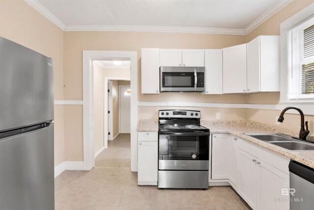 kitchen with stainless steel appliances, a sink, white cabinetry, and ornamental molding