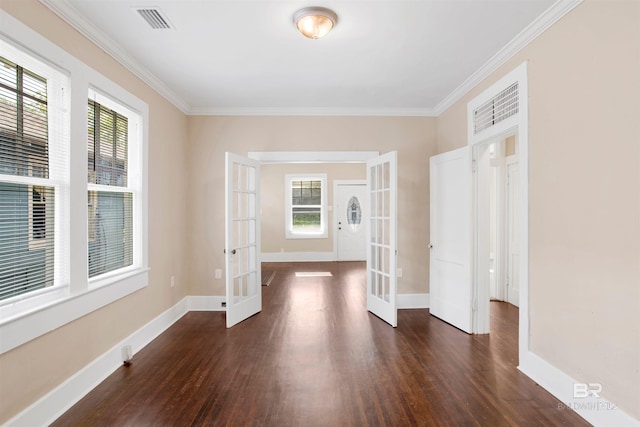 spare room featuring french doors, dark wood-style flooring, and a healthy amount of sunlight