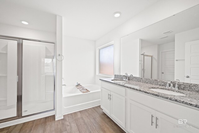 14705 Forsythia Loop, Silverhill, AL 36576 - full bath featuring a stall shower, a bath, wood finished floors, double vanity, and recessed lighting