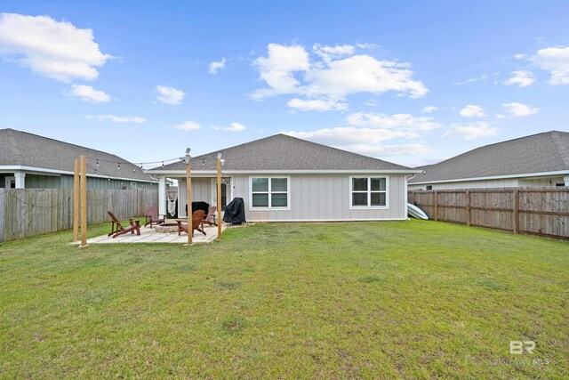 14705 Forsythia Loop, Silverhill, AL 36576 - back of property featuring a patio area, a fenced backyard, an outdoor fire pit, and board and batten siding