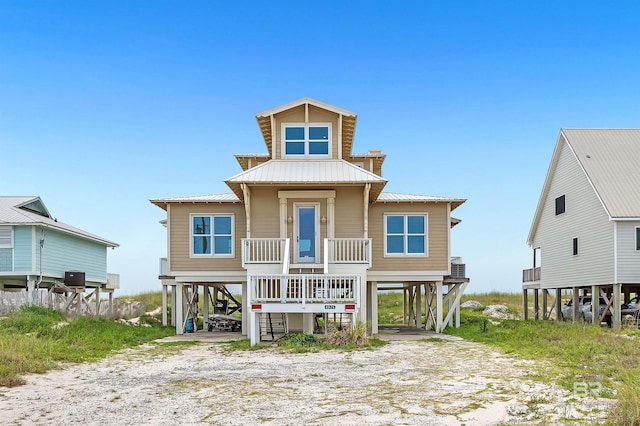 raised beach house featuring a carport and a porch