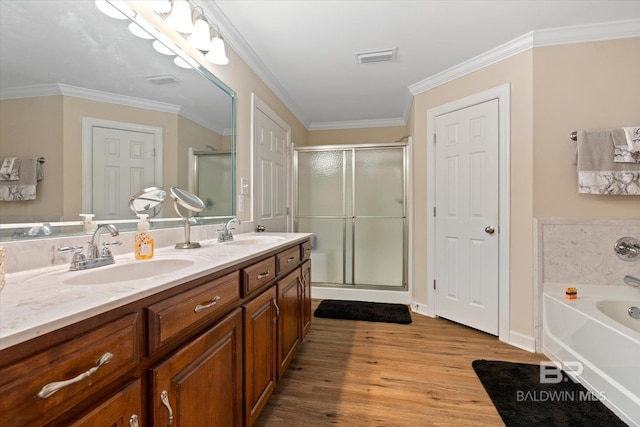 full bath with a sink, a garden tub, wood finished floors, and a shower stall