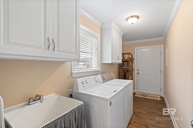 laundry area with wood finished floors, cabinet space, a sink, crown molding, and washer and clothes dryer