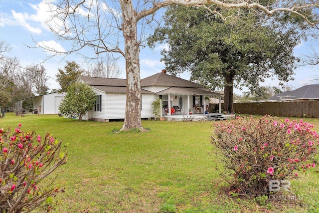 rear view of property with a chimney, fence, a lawn, and a shingled roof