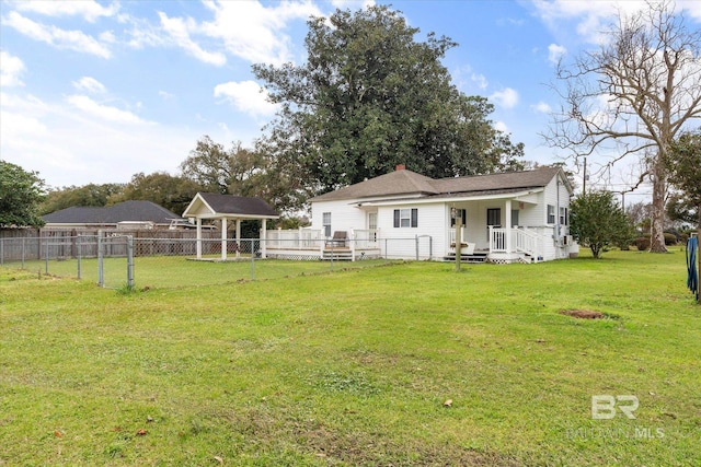 rear view of property with a chimney, a yard, and fence