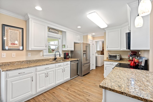 kitchen featuring light wood-style flooring, a sink, white cabinetry, stainless steel appliances, and crown molding