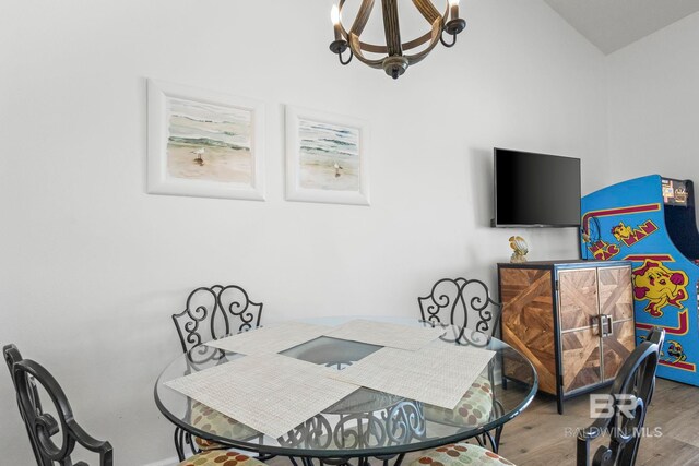 dining space featuring wood finished floors and a notable chandelier
