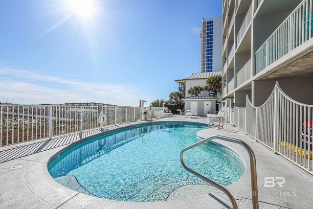 community pool featuring a patio area and fence