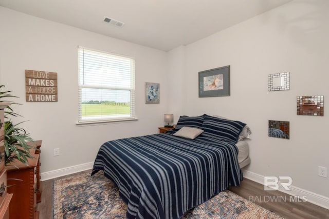 bedroom featuring baseboards and wood finished floors
