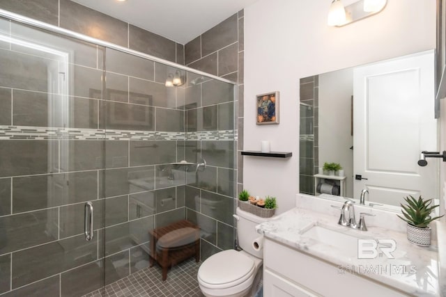 bathroom with a shower stall, vanity, and toilet