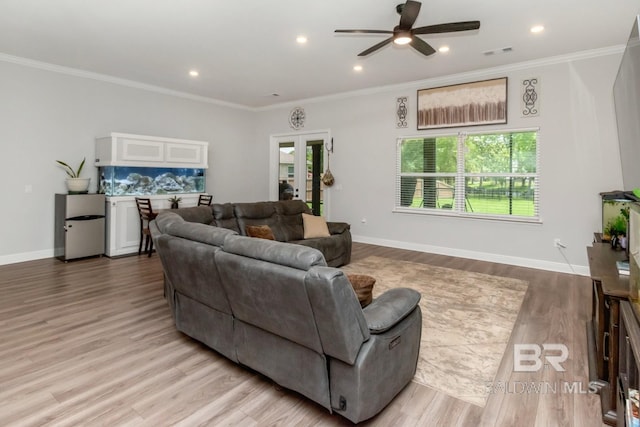 living room with a ceiling fan, wood finished floors, ornamental molding, baseboards, and recessed lighting