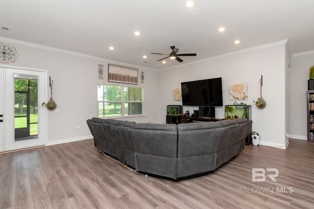 living room featuring ornamental molding, plenty of natural light, baseboards, wood finished floors, and recessed lighting