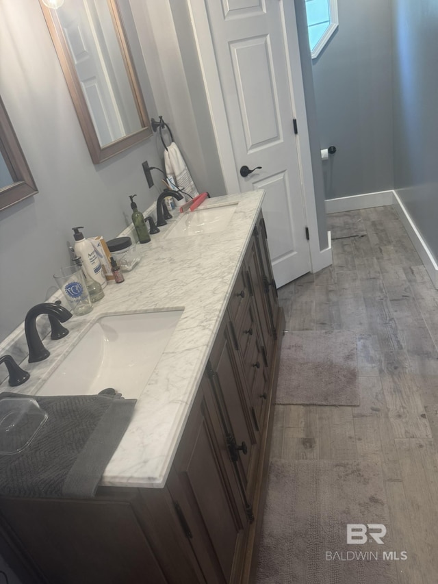 32098 Jessup Ln, Lillian, AL 36549 - bathroom featuring wood finished floors, double vanity, and baseboards